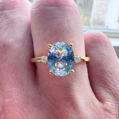 a woman's hand with a ring on it and a blue stone in the middle