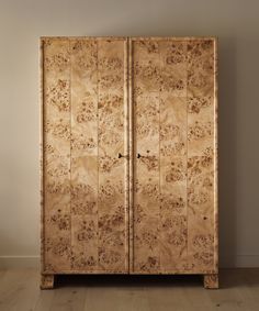 a wooden cabinet sitting on top of a hard wood floor next to a white wall