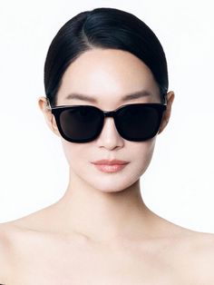 a woman wearing black sunglasses is posing for the camera