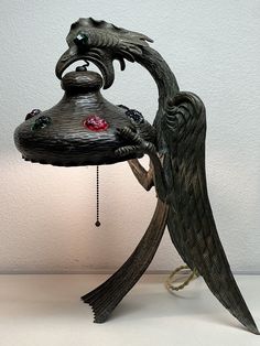 a bird lamp with an intricate design on it's face and wings attached to the base