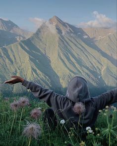 a person with their arms outstretched in the mountains