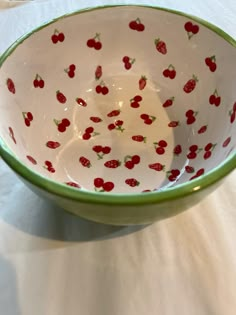 a green and white bowl with strawberries on it