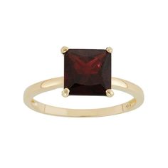 a gold ring with a red stone in the center