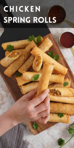 chicken spring rolls on a cutting board with dipping sauce