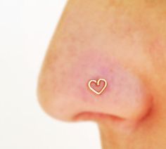 a close up of a person's nose with a small heart on it