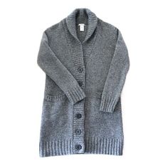 Step into the nostalgia of the 90s with this exquisitely made GAP cardigan, a blend of classic style and cozy comfort.       *   Authentic Vintage Quality: Sourced from the iconic 1990s, this GAP cardigan embodies classic comfort with timeless style.       *   Premium Material: Crafted from 100% lambswool, ensuring a soft, warm, and luxurious feel.       *   Unique Design: Features a sophisticated midi length that reaches mid-thigh, perfect for layering over your favorite outfits.       *   Deta Classic Gray Cardigan For Fall, Cozy Wool Cardigan For Winter, Cozy Wool Sweater With Button Closure, Charcoal Wool Sweater For Fall, Classic Gray Wool Cardigan, Classic Soft Knit Sweater Coat For Winter, Cozy Wool Sweater Coat With Button Closure, Classic Gray Knit Cardigan, Gray Wool Cardigan For Winter