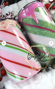 two pink, green and white striped luggage bags sitting next to each other on top of a pile of christmas decorations