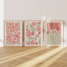 three framed art prints on a wall in an empty room with wood flooring and sunlight coming through the window