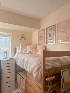 a bed room with a neatly made bed next to a dresser and drawers in front of a window