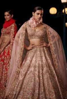 Editor's Note The blush peach raw silk bridal lehenga set comes with a matching raw silk embroidered blouse and two tulle dupattas. The lehenga is adorned with gold and thread embroidery, adding a touch of elegance and sophistication to the overall look. Fabric: Raw silk and tulle Color: Blush peach Components: Lehenga, blouse and two dupattas Occasion: Reception Disclaimer: Product color may slightly vary due to photographic lighting sources or your monitor setting. Care: Dry clean only About t Plunge Neck Blouse, Dolly J, Silk Bridal Lehenga, Peach Lehenga, Embroidered Bridal Lehenga, Indian Outfits Lehenga, Color Embroidery, Red Lehenga, Silk Tulle