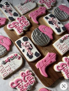 decorated cookies with pink and black designs on a wooden board next to the words i love you