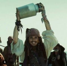 a group of people dressed in pirate costumes on a ship with one person holding up a cup