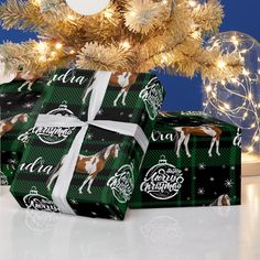 two wrapped presents under a christmas tree with lights