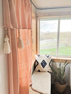 a room with a window, chair and potted plant next to the window sill