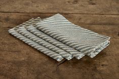 four folded napkins sitting on top of a wooden table