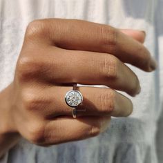 a woman's hand with a diamond ring on it