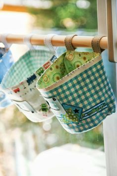 three cups are hanging from a clothes line