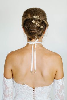 the back of a woman's wedding dress, with her hair in a bun