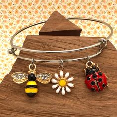 Bee Bracelet, Ladybug Bracelet, Flower Bracelet, Garden Bracelet, Spring Bracelet, Gift for Gardener, Bee Bangle Bracelet, Bee Charm  ️ Keep spring in your heart...and on your wrist...all year long! - charms are  comprised of skin safe enamel - come gift ready  in a cute organza bag  - bracelets are  hypoallergenic stainless steel, in a gold or plain silver       finish - bracelets are adjustable Please choose either a gold or silver bracelet.  All charms are gold and jump rings will match the b Adjustable Flower Bracelets With Lobster Clasp, Adjustable Flower Charms Bracelets, Adjustable Flower-shaped Bracelets With Charms, Adjustable Flower-shaped Charm Bracelets, Adjustable Metal Bracelet With Flower Charm, Adjustable Metal Charm Bracelet With Flower Charm, Ladybug Bracelet, Bee Bracelet, Gift For Gardener