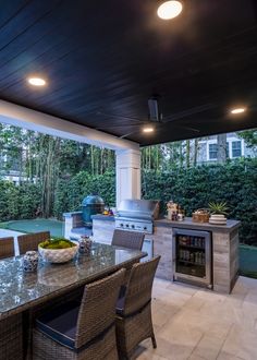 an outdoor kitchen with grill and dining table