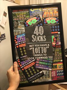 a person holding up a framed poster with the words 40 sucks but you have 4 lotto