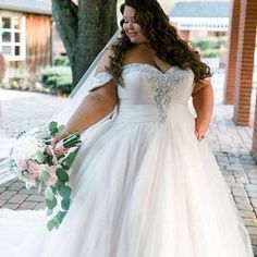 a woman in a wedding dress is walking down the street