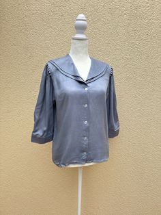 "Beautiful and unique blouse by Evelyn Dejonge Petite in dove blue color made in British Crown Colony of Hong Kong.  This rare blouse features double layered round sailor collar, button down closure, slightly padded shoulders with ruched 3/4 sleeves buttoned at the cuff. 100% rayon.  Excellent vintage condition.  Marked size 6. For a proper fit please see the measurements below. Measurements (flat): Shoulder to shoulder: 15\" Armpit to armpit: 18,5\" Sleeve length: 16\" Waist: 36\" Shoulder to h Elegant Half Sleeve Blouse For Daywear, Elegant Blue Half Sleeve Top, Blue Fitted Half-sleeve Blouse, 3/4 Sleeve Blouse With Button Closure For Daywear, Light Blue Short Sleeve Blouse For Fall, Fall Light Blue Short Sleeve Blouse, Blue Half Sleeve Blouse With Button Closure, Blue 3/4 Sleeve Tops For Daywear, Formal Summer Tops With 3/4 Sleeves