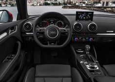 the interior of an automobile with dashboard, steering wheel and dash lights in front of a city view