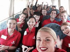 a group of people in red shirts posing for a photo with the caption fancy climbing on the emirates bus? let your new career begin