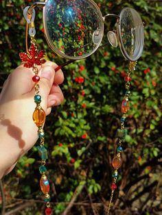 Introducing our new enchanting glasses chain, a mesmerizing accessory that captures the essence of fairy allure.  Adorned with maple leaf charms, dazzling teal, orange and red beads, and green tiger eye square beads, this glasses chain exudes an ethereal charm.  This eyeglass chain might be slightly heavier than regular chains because of some stone beads and crystals. Actual colors of any item or chains may slightly differ from screen to screen due to the screen resolution. I take our pictures i Handmade Bohemian Glasses Chains For Party, Handmade Elegant Glasses Chains For Festivals, Bohemian Handmade Glasses Chains For Party, Elegant Handmade Glasses Chains For Festivals, Elegant Handmade Festival Glasses Chains, Witchy Glasses, Glasses With Beads, Fairy Glasses, Fantasy Glasses