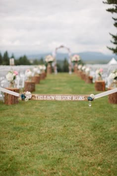 the aisle is decorated with flowers and ribbons for guests to sit down on, along with their names