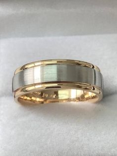 two tone gold and silver wedding bands on white cloth with one ring in the middle