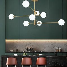 a modern kitchen with green walls and marble counter tops, pink chairs and a gold chandelier hanging from the ceiling