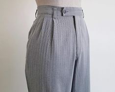 Vintage Gray Straight Leg Pants  - Fabric : 100% wool  - Nylon zipper on the front - Pockets - Made in Japan Good vintage condition but the pants has a flaw. Please see the last photo. Measurements : Waist : 30" Hips : 40" Front rise : 12" Back rise : 17.5" Inseam : 28" Total length : 38.5" Width of hem : 17" Our products are vintage clothing that will be cleaned so you can be confident in the quality. We carefully inspect each garment to make sure that you get the most accurate and informed description possible. We do our best to state any imperfections in the listing. If a flaw accidentally escapes our inspection, please let me know as soon as possible and we will be happy to help remedy the situation. Please read the product description carefully before purchasing to ensure it meets you High Waist Wool Bottoms For Formal Occasions, Tailored High Waist Wool Bottoms, High Waist Wool Bottoms With Pockets, Gray Relaxed Fit High Waist Pants, Tailored High Waist Wool Pants, Fitted High Waist Wool Pants, Vintage Wool Pants For Formal Occasions, Fitted Wool High Waist Bottoms, Fitted High Waist Wool Bottoms