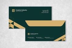 two green and gold business cards sitting on top of a white surface with the words creative industry