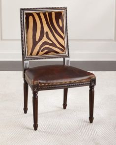 a zebra print chair sitting on top of a white carpeted floor next to a wall