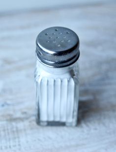 a salt shaker sitting on top of a wooden table