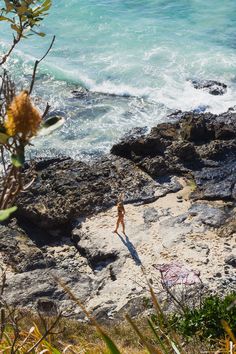 a person standing on rocks near the ocean