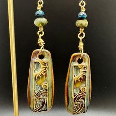 These fun boho earrings with ceramic artisan charms feature a sun and moon design. The earrings are accented with blue apatite and green agate semi-precious gemstones. They have gold artistic wire and hypoallergenic titanium ear wires in a matte silver color.  The colors in the photos are as close to the colors represented in person, but there might be a slight variation depending on computer or phone screens. Unique Sun And Moon Dangle Earrings, Unique Sun And Moon Design Dangle Earrings, Unique Dangle Earrings With Sun And Moon Design, Bohemian Czech Glass Jewelry For Everyday, Bohemian Sun Design Adjustable Earrings, Everyday Bohemian Czech Glass Jewelry, Bohemian Dangle Earrings With Sun And Moon Design, Unique Sun And Moon Design Dangle Jewelry, Artsy Czech Glass Dangle Jewelry