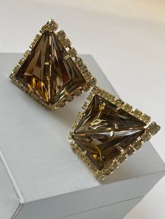 "Listed is a pair of show-stopping large triangular shaped rhinestone earrings done in a brilliant color topaz from the 40s or 50s. These beauties are either a prized pieces of Juliana jewelry or an unsigned pair of earrings done by the famous Elsa Schiaparelli. This is a FABULOUS pair of earrings have stood the test of time and they are ready for wear. These earrings are made of large triangular shaped stones, accented with smaller round glass rhinestones, the color is beautiful. The matching b Schiaparelli Jewelry, Juliana Jewelry, Fake Earrings, Trifari Brooch, Bridal Clip, Velvet Pumps, High End Jewelry, Elsa Schiaparelli, Bronze Jewelry