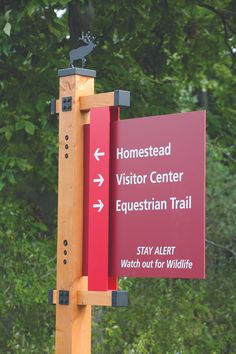 a red sign that is on the side of a pole with trees in the background