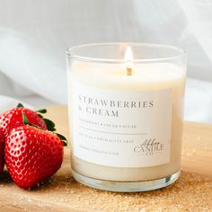 a candle and two strawberries on a table