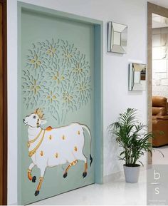 a cow painted on the side of a door next to a potted plant