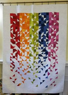 a multicolored quilt hanging from a shower curtain