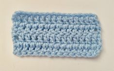 a blue crochet dishcloth on a white surface with a small hole in the middle