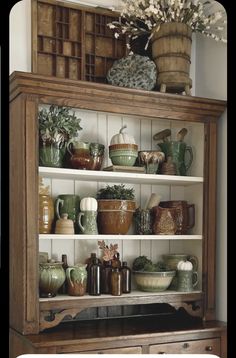 an old china cabinet is filled with dishes and vases