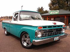 an old pickup truck parked in front of a building