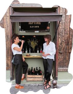 two women sitting at a table with bottles