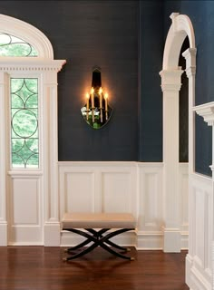 a room with blue walls and wood floors, two chandeliers hanging from the ceiling