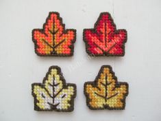 four small autumn leaf magnets on a white surface